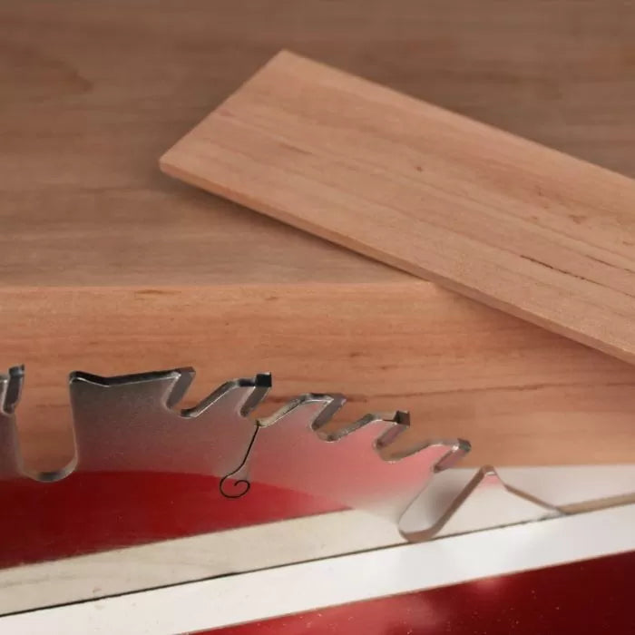 Close-up of a table saw blade with two wooden boards, woodworking tools setup