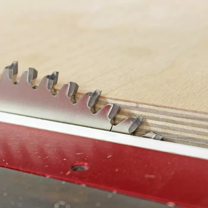Close-up of a circular saw blade cutting plywood on a table saw for woodworking