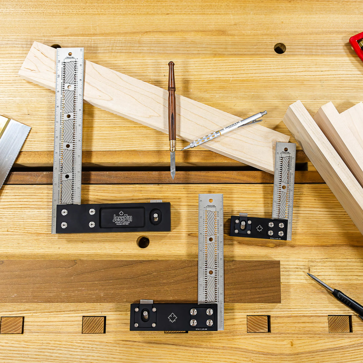 Set of precision woodworking squares and rulers on a workbench with wood pieces and marking tools