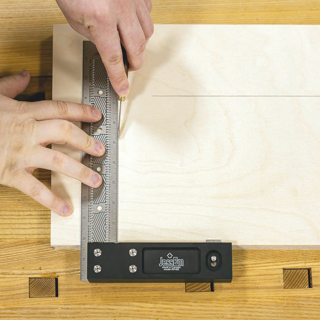 Woodworker using a JessEm precision marking tool and ruler to scribe a line on plywood.