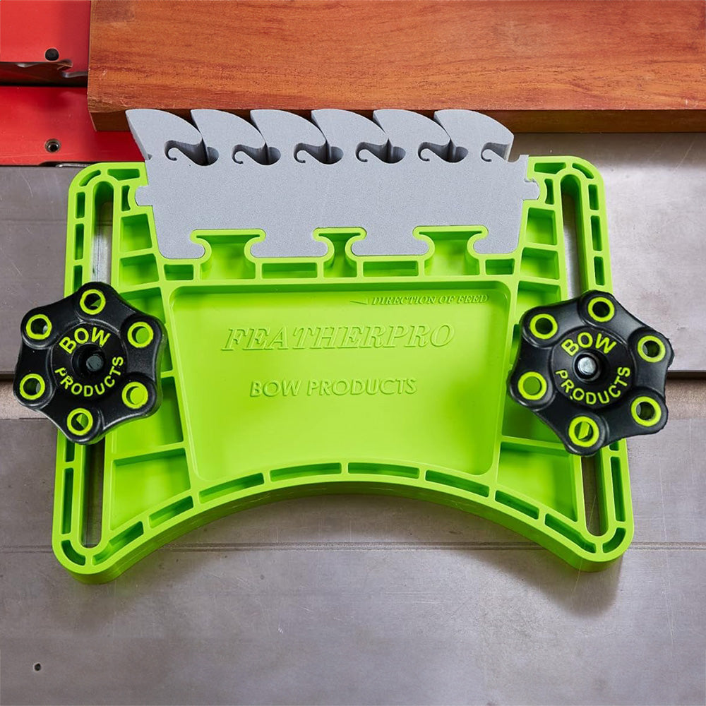 Featherboard woodworking safety tool clamped to table saw with wood piece, bright green design