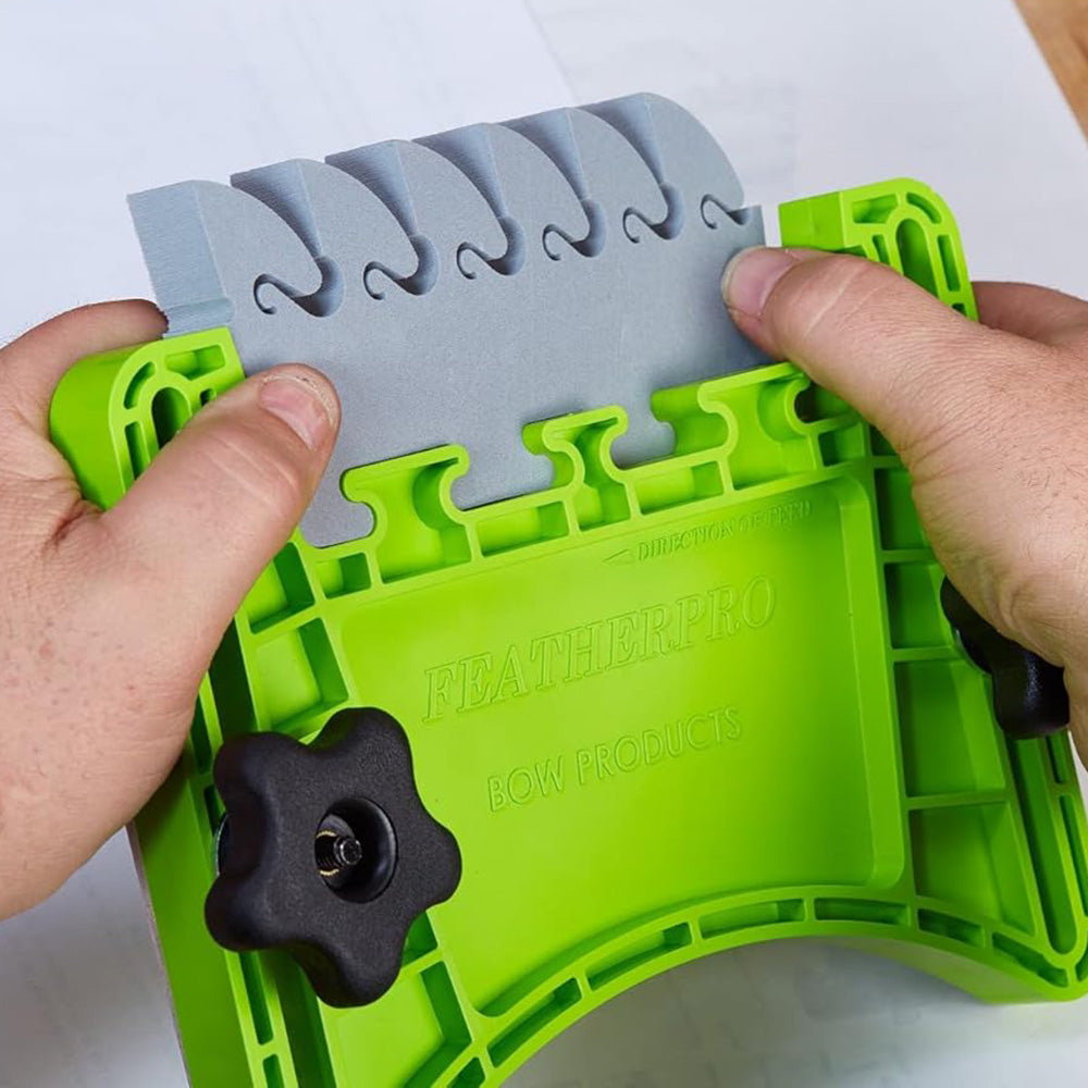 Hands adjusting green FeatherPro featherboard for woodworking safety and precision.