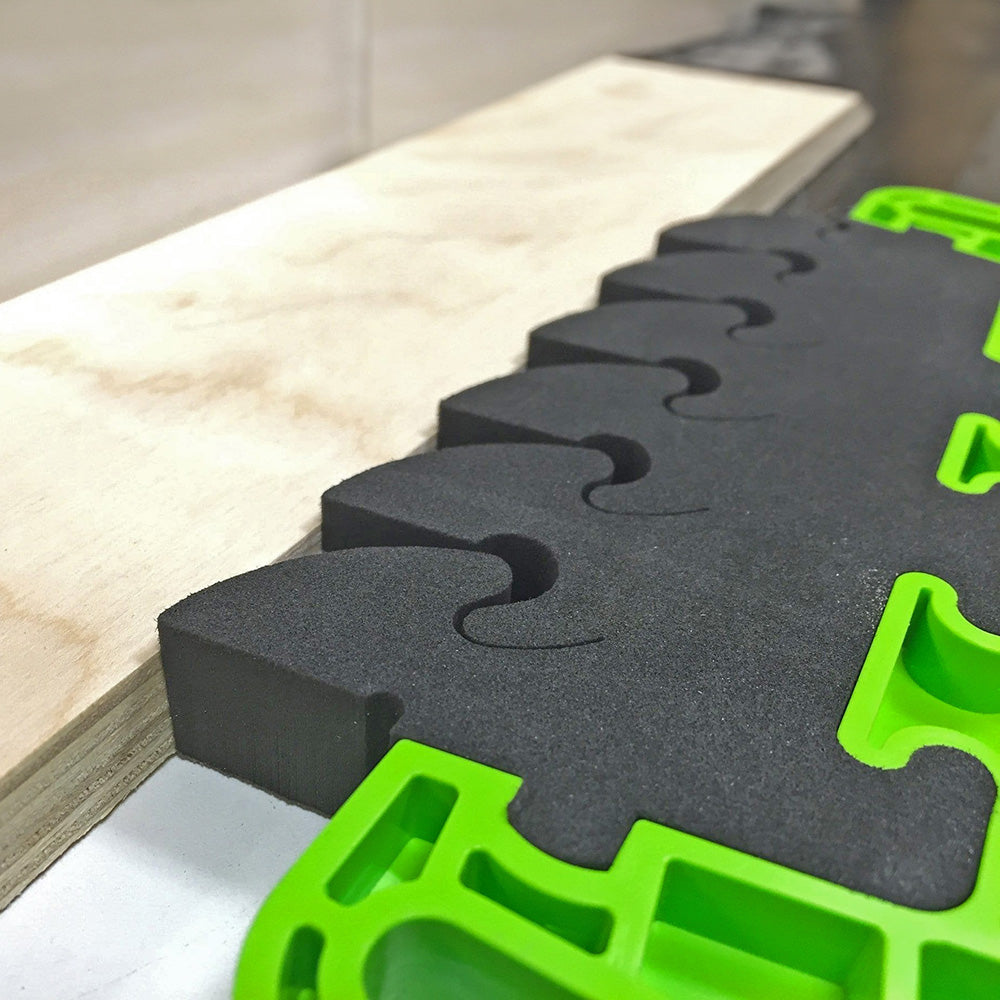 Foam bench dog pad with green frame holding plywood, woodworking accessory for workbenches