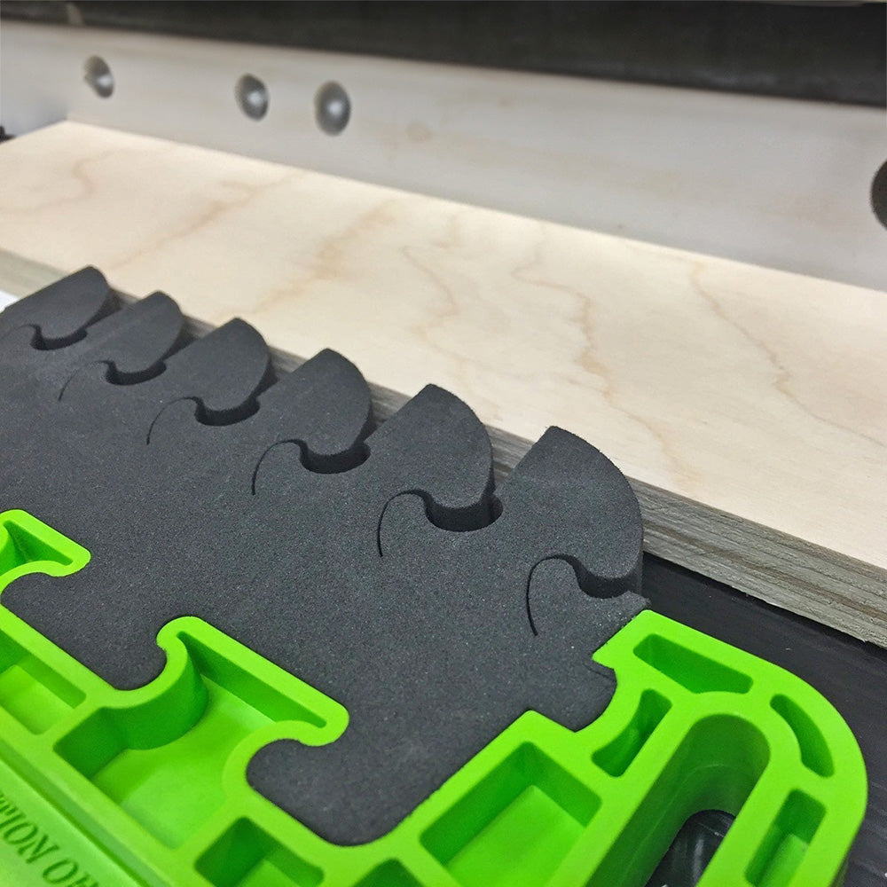 Woodworking featherboard holding plywood on a router table for precise cutting