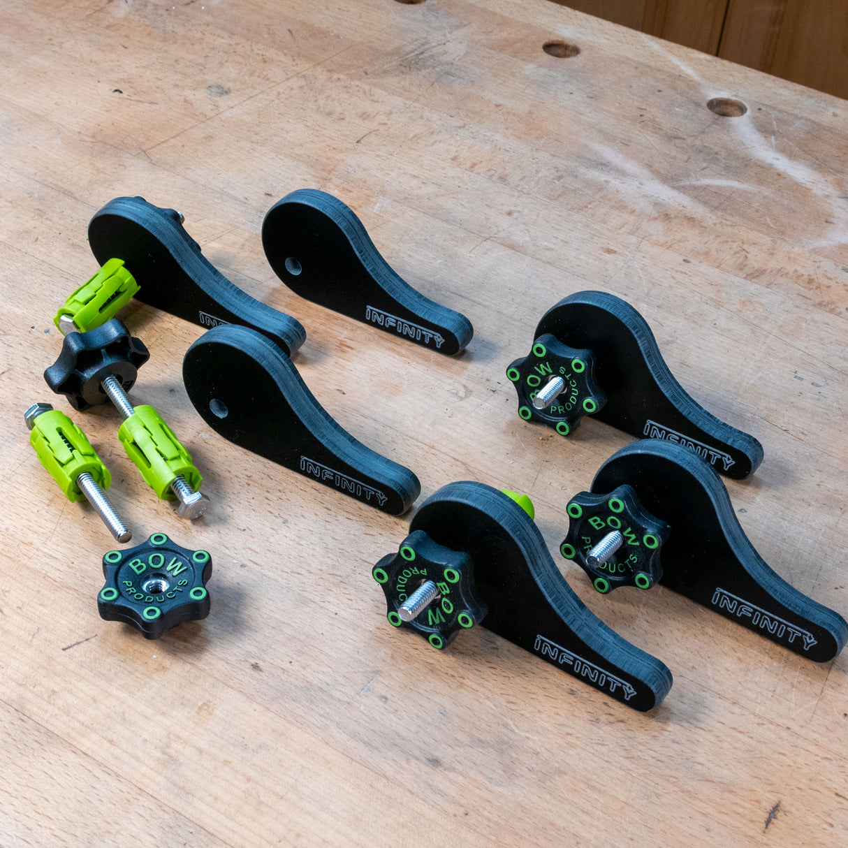 Eccentric cam clamp set with black and green hardware on a wooden workbench