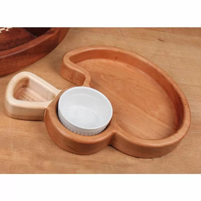 Wooden appetizer tray with integrated ramekin and dip holder on a workbench