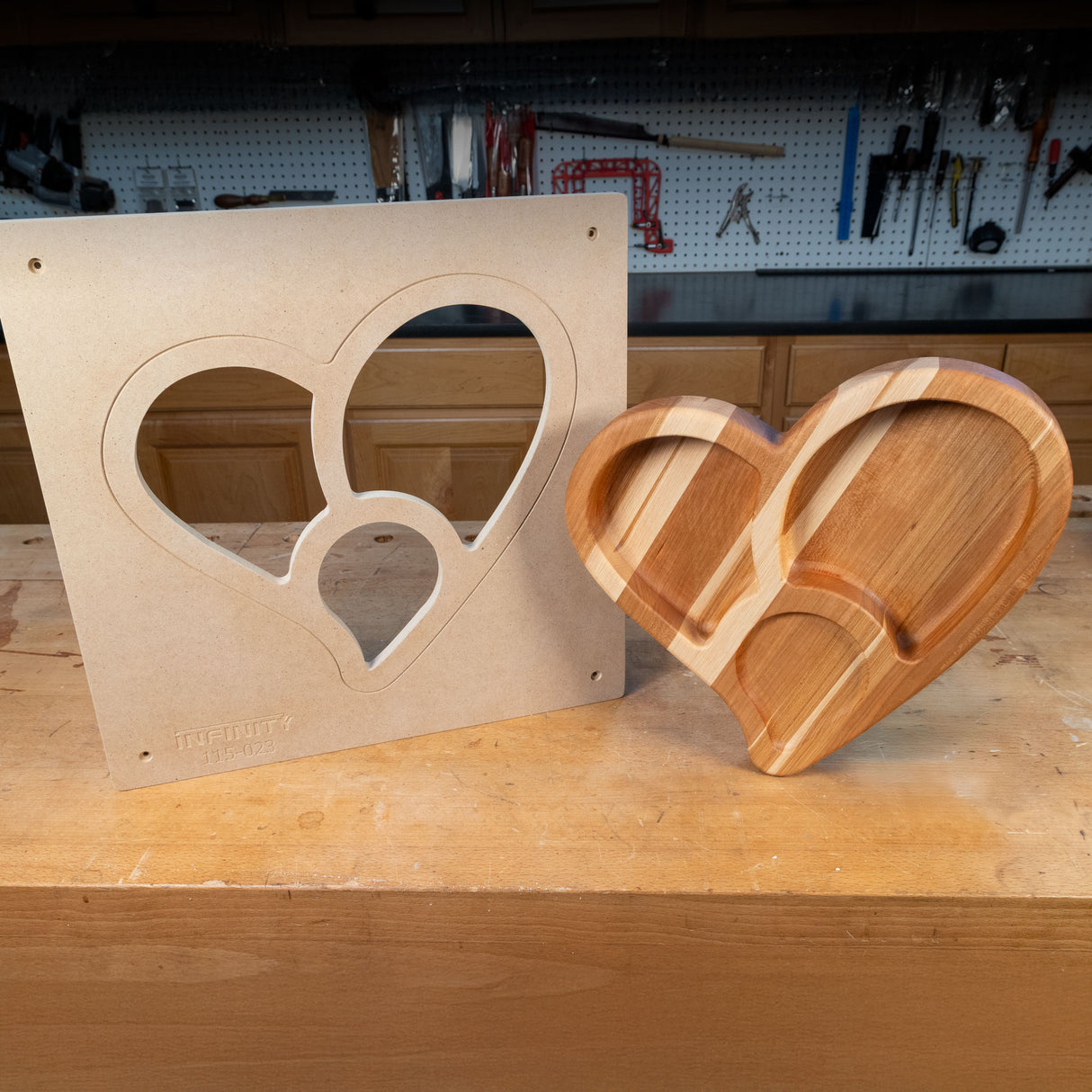 Heart-shaped woodworking template and finished wooden tray on a workshop bench