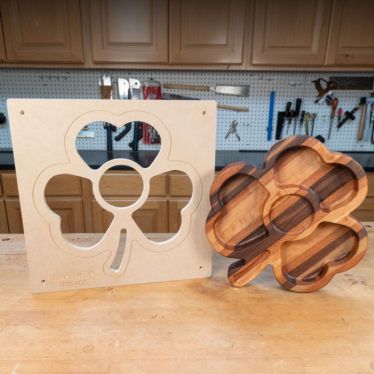 Shamrock-shaped woodworking template and finished wood tray on workbench in a workshop.