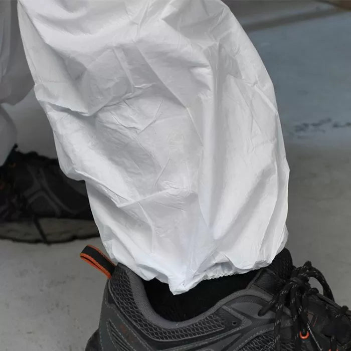 Protective disposable coveralls over work shoes on workshop floor