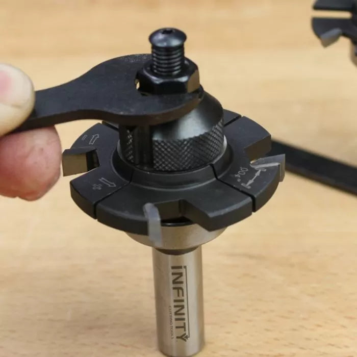 Close-up of adjustable woodworking router bit with wrench being used on workbench