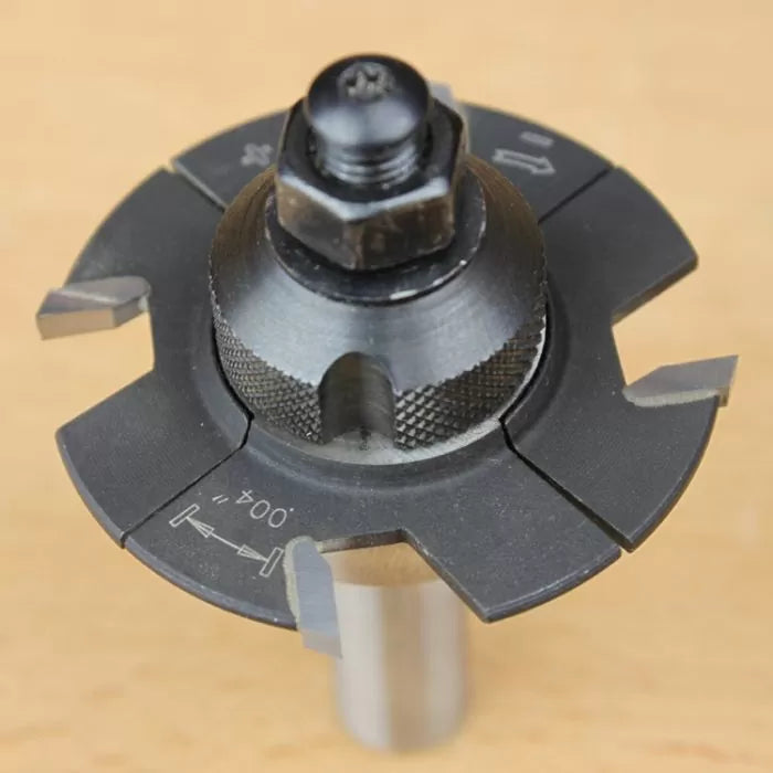 Close-up of adjustable woodworking router bit with carbide tips on a light surface