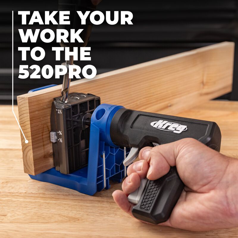 Hand holding a Kreg Pocket Hole drill guide on a wooden surface.