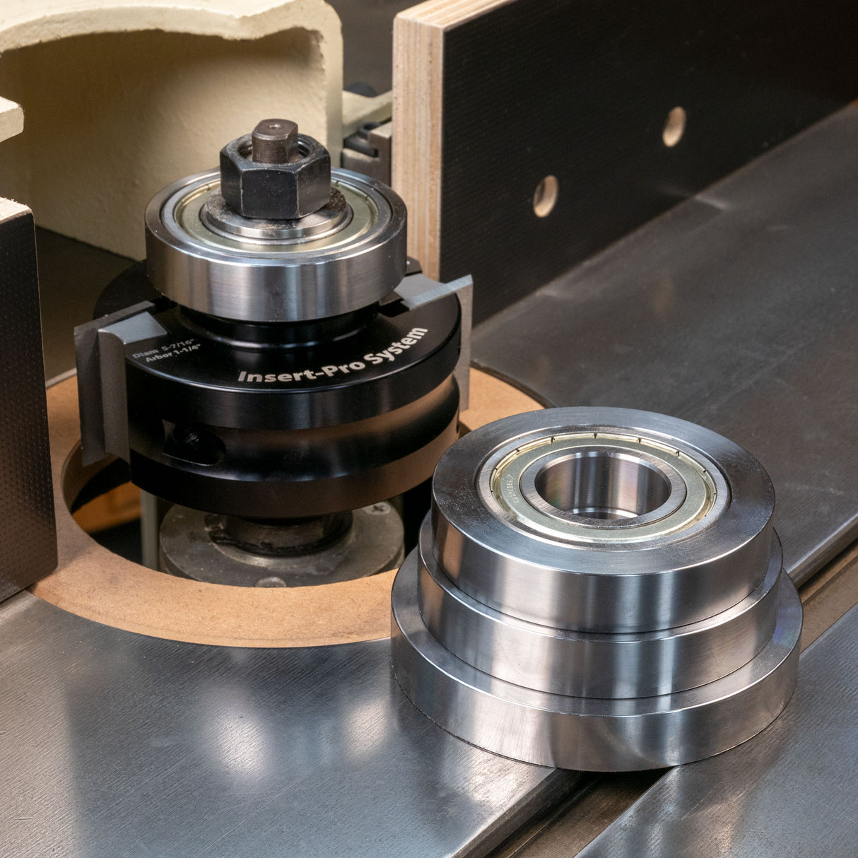 Router table spindle with metal rub collars and bearings for woodworking tool setup