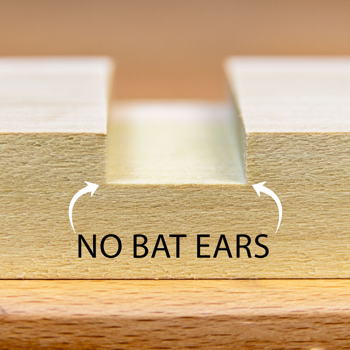 Cut from a stacked dado set with flat top blades resulting in no bat ears.