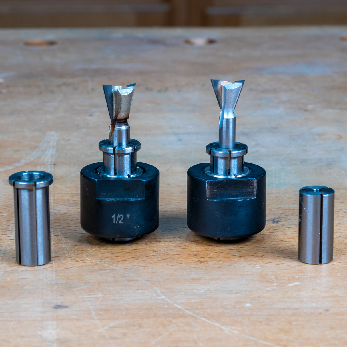 Router collet reducing sleeves and router bits on wood workbench