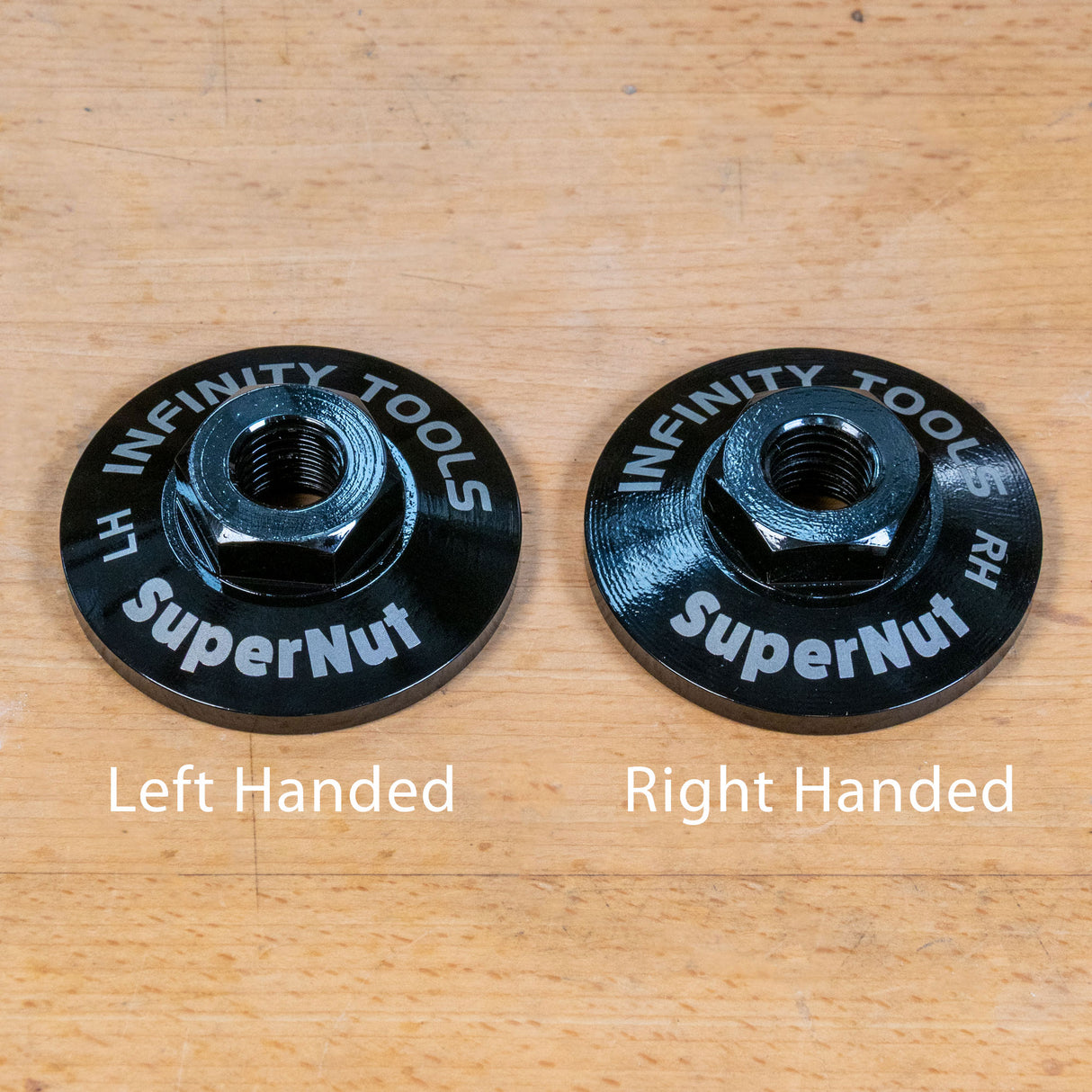 Two black circular metal tool pieces labeled 'INFINITY TOOLS SuperNut' with white text indicating handedness, shown on a light wood surface. The left piece is labeled 'Left Handed' and the right piece 'Right Handed'.