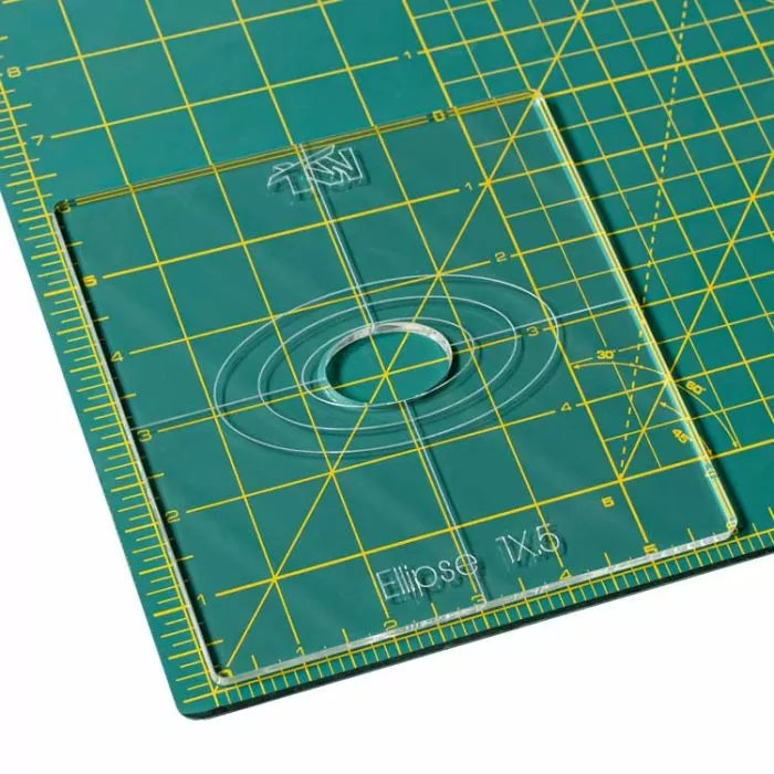 Acrylic ellipse template on a green cutting mat with yellow grid lines for woodworking projects.