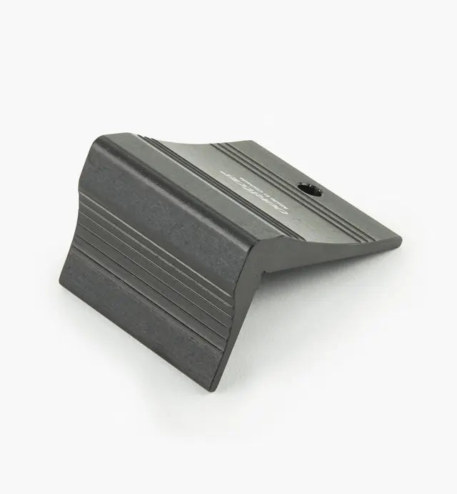 Black aluminum woodworking jig accessory with grooved surface on a white background