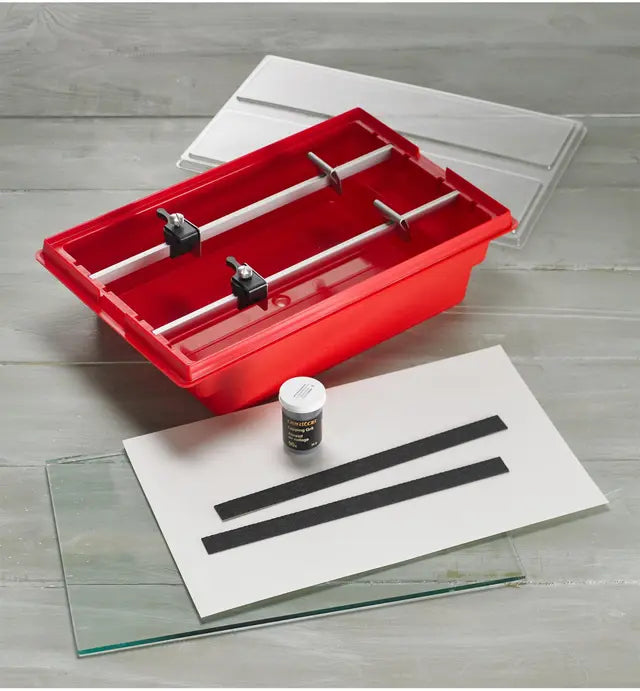 Woodworking sharpening system kit with red tray, glass plates, abrasive strips, and honing compound.