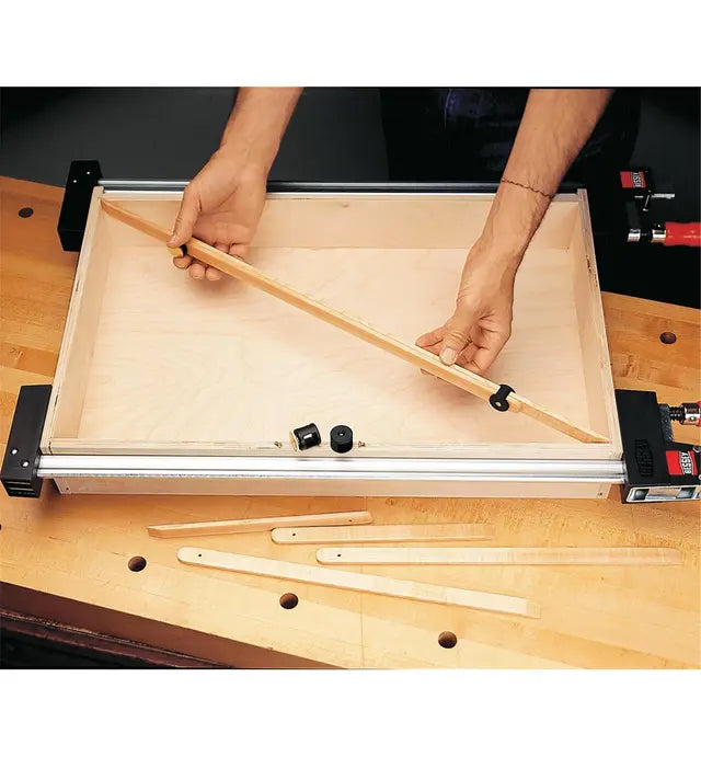Woodworker adjusting a miter gauge jig for precise woodworking on a workbench.