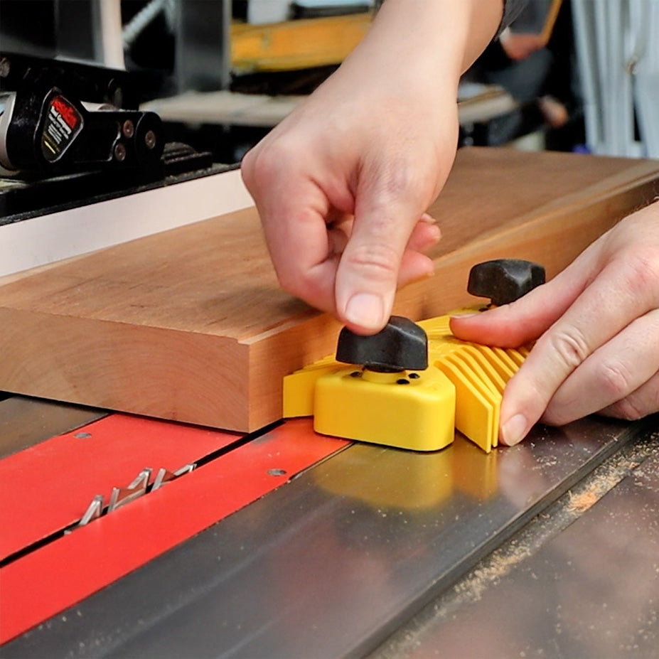 Locking the featherboard at the table saw.