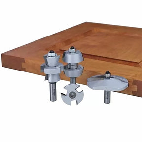 Woodworking router bits set with carbide cutting edges displayed beside a cabinet door panel.