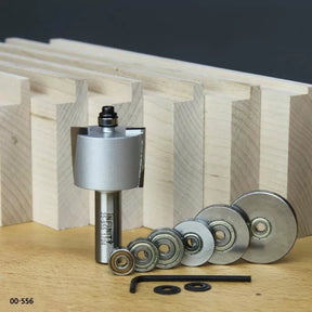 Router bit and bearing set with hex key for woodworking, displayed in front of dovetail jointed wood pieces.