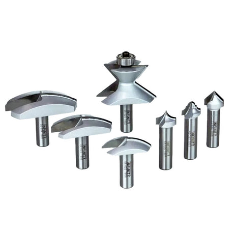 Set of seven carbide woodworking router bits in various profiles on a white background