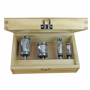 Set of four woodworking router bits in a wooden storage box