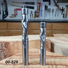 Two spiral flush trim router bits with ball bearings for woodworking on a workbench.