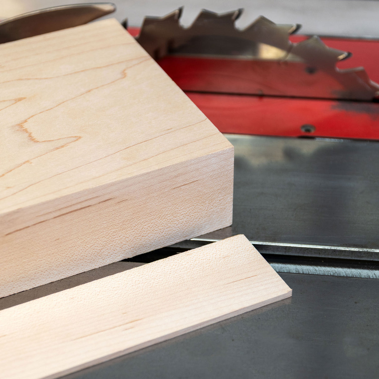 Wooden plank being cut by a circular saw on a table.