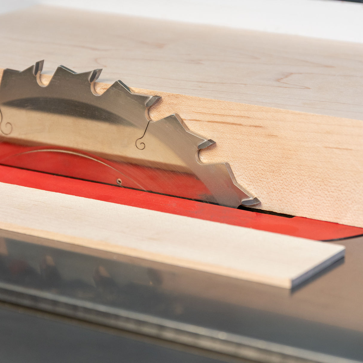 Wooden table saw blade with metal teeth on a wooden surface