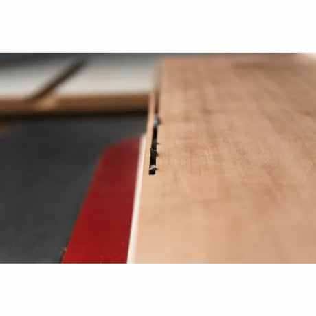 Close-up of a dado cut in wood on a table saw, woodworking tools in use