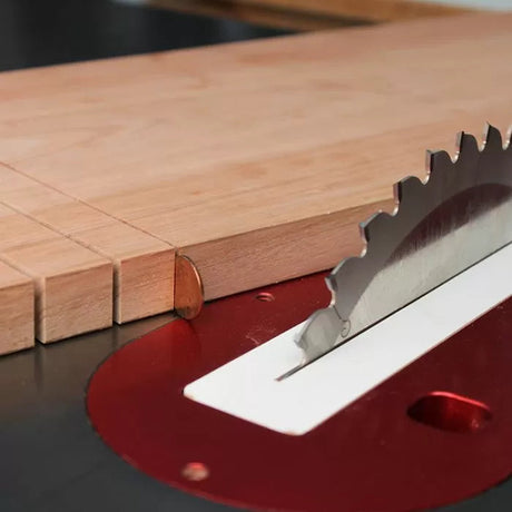 Close-up of a table saw cutting evenly spaced grooves in a wooden board for woodworking