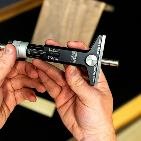Close-up of hands holding a micrometer tool against a blurred background