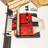 Router table with red base and wooden pieces on a white background