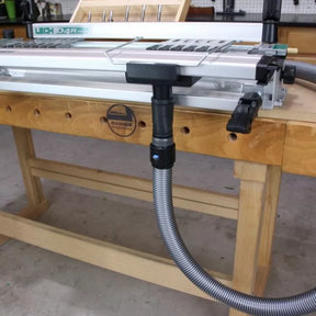 Dovetail jig with dust collection hose attached on woodworking bench