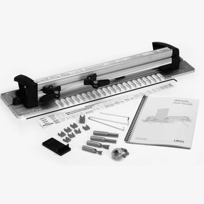 Dovetail jig set with guide, router bits, stops, and user manual on a white background