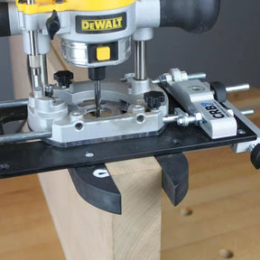 Plunge router with edge guide jig attached to wood, woodworking tool in use