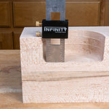 Wooden block with a metal tool labeled 'Infinity Cutting Tools' on a wooden surface.