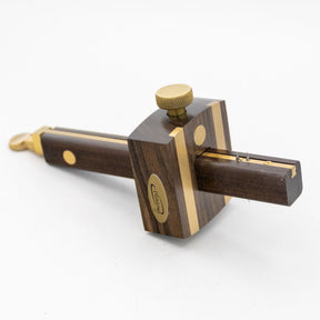 Ebony marking gauge with brass accents for woodworking on a white background