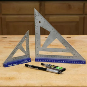 Metal woodworking bench squares, pencil, and lead refill on a wood workbench.