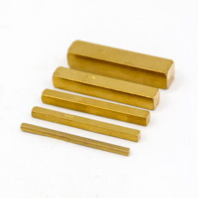 Set of brass setup bars in various sizes on a white background for woodworking precision