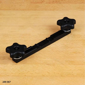 Router table hold-down clamp with two adjustable knobs on a wood surface
