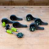 Eccentric cam clamp set for woodworking, black and green hardware on a workbench.