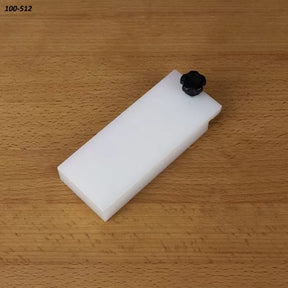 Rectangular white table saw accessory with black knob on wood surface, woodworking tool