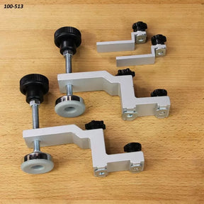 Set of adjustable woodworking hold-down clamps on a wooden workbench surface