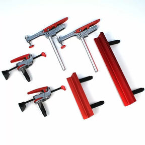 Set of woodworking clamps and red aluminum fence accessories on a white background