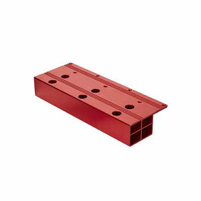 Red aluminum woodworking jig block with multiple holes for precision tool setup