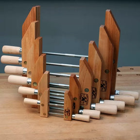 Set of wooden handscrew clamps for woodworking on a workbench, metal threaded rods